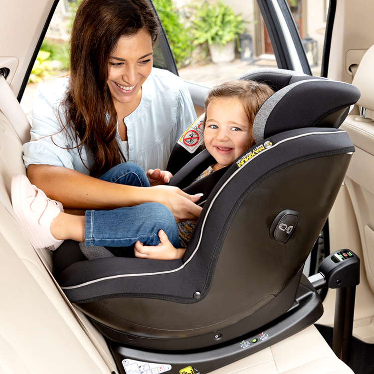 Maman ajustant le harnais d’un enfant assis dans le siège-auto Graco Ascent