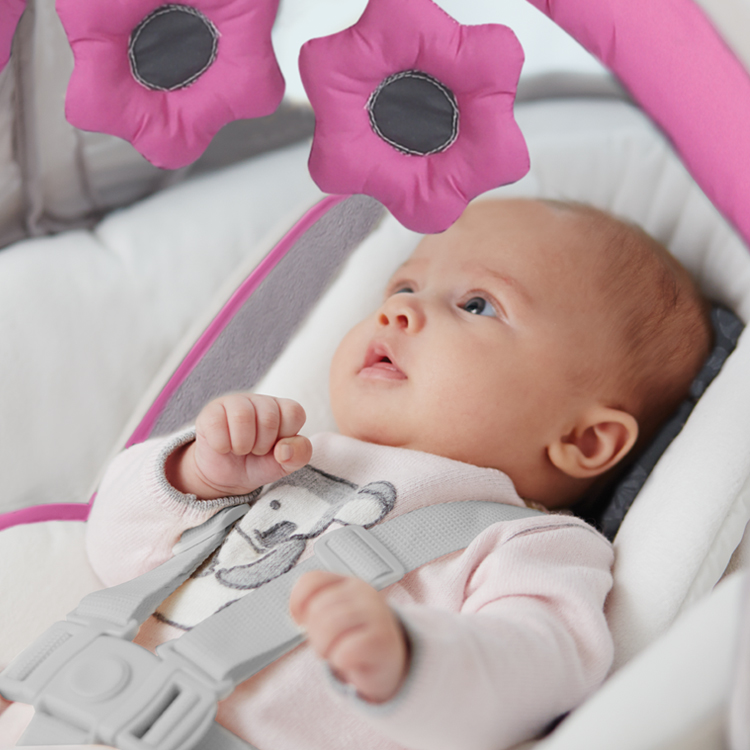 Baby looking at the soft toys on Graco Glider Elite