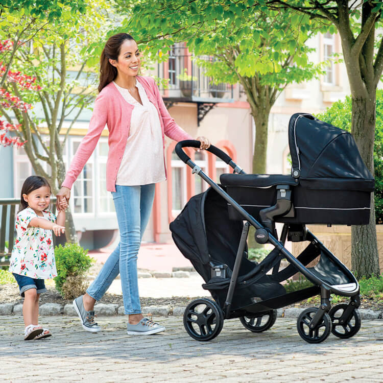 Mum pushing kids in Graco Time2Grow double stroller
