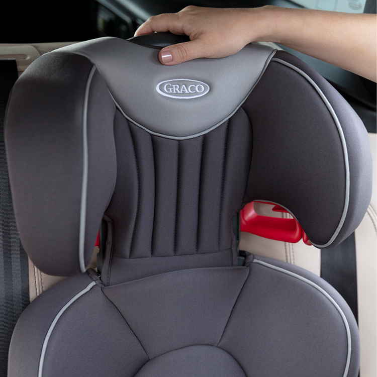 A hand adjusting the height of the Graco Logico L headrest