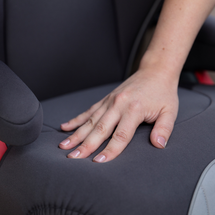 A person touching the padded seat cushion of the Graco Logico L car seat