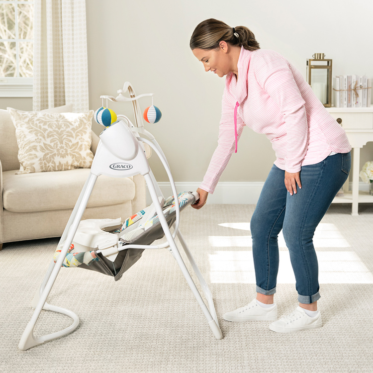 Frau neigt die Rückenlehne der elektrischen Babyschaukel Graco Lovin' Hug