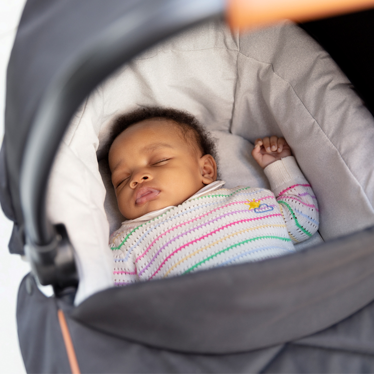 Baby sleeping in Graco Near2Me Elite carrycot