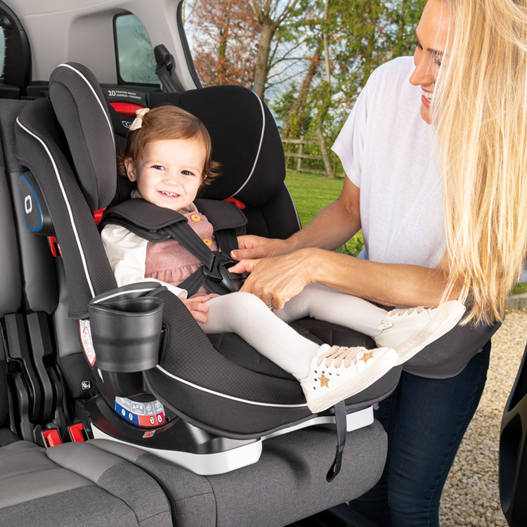 Mom smiling at little girl sitting forward facing in Graco SlimFit LX car seat